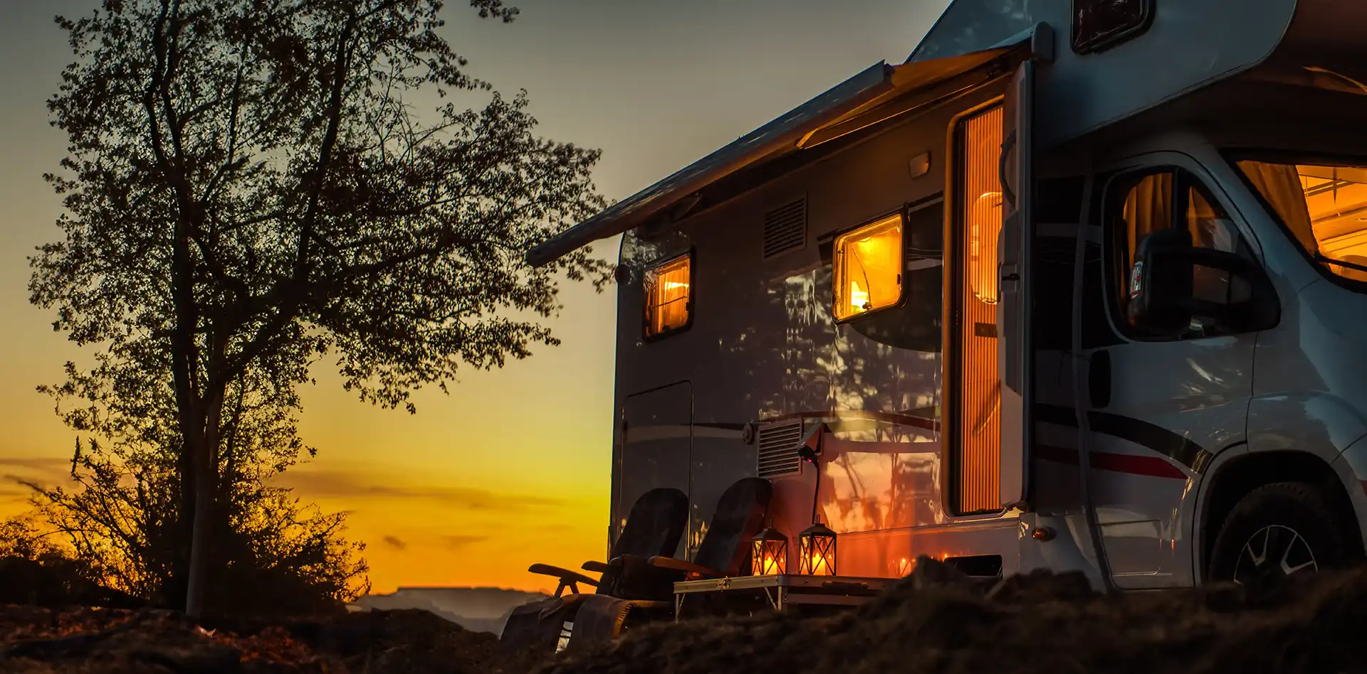 Camper auf einem Stellplatz bei Sonnenuntergang