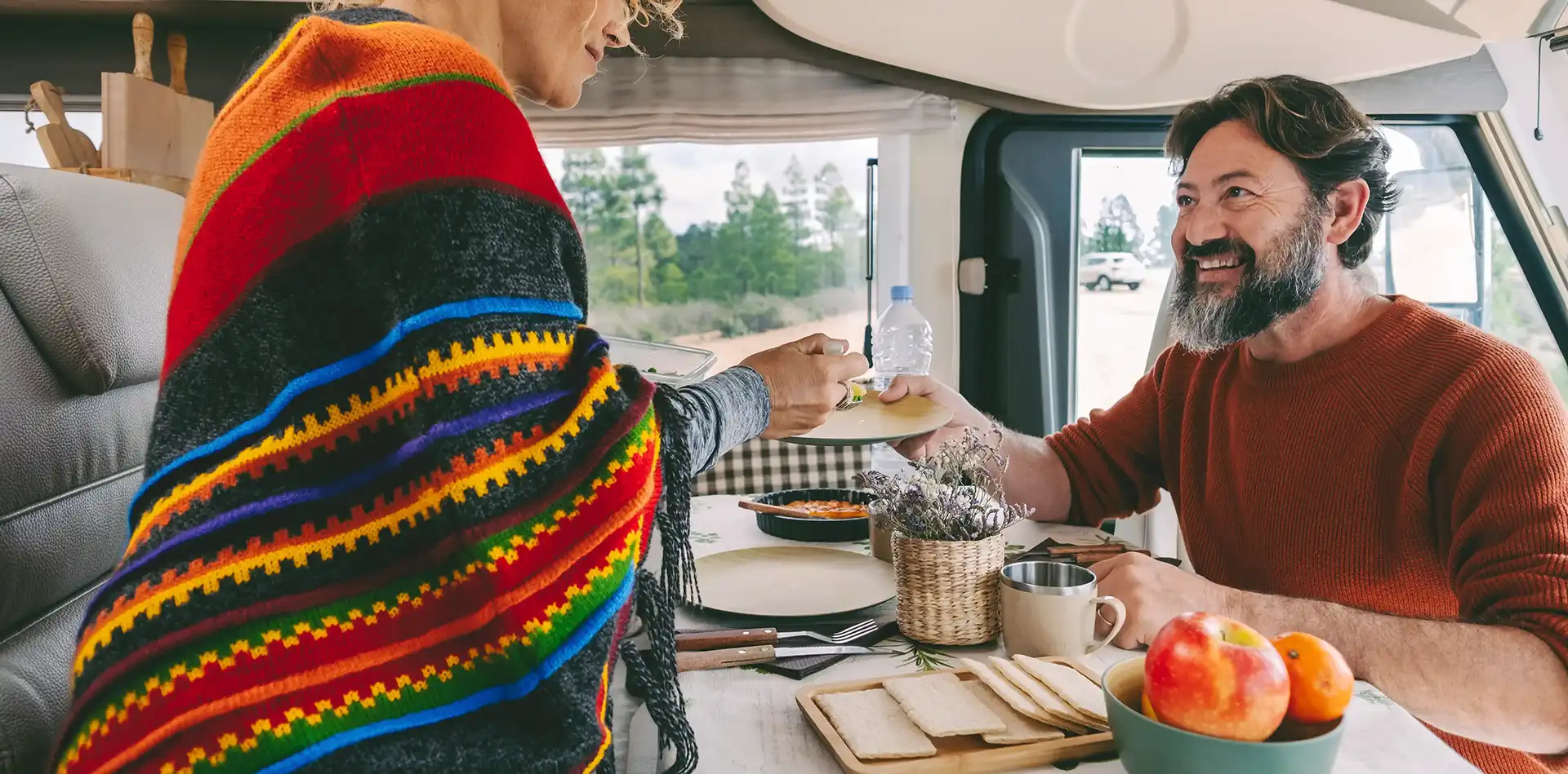 Ein Pärchen sitzt in einem Camper und geniesst das Mittagessen zusammen